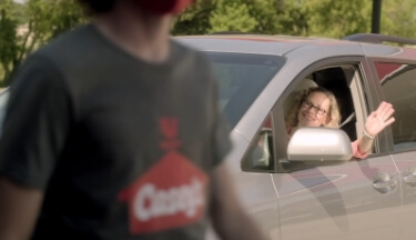 person waving at Casey's team member from their car
